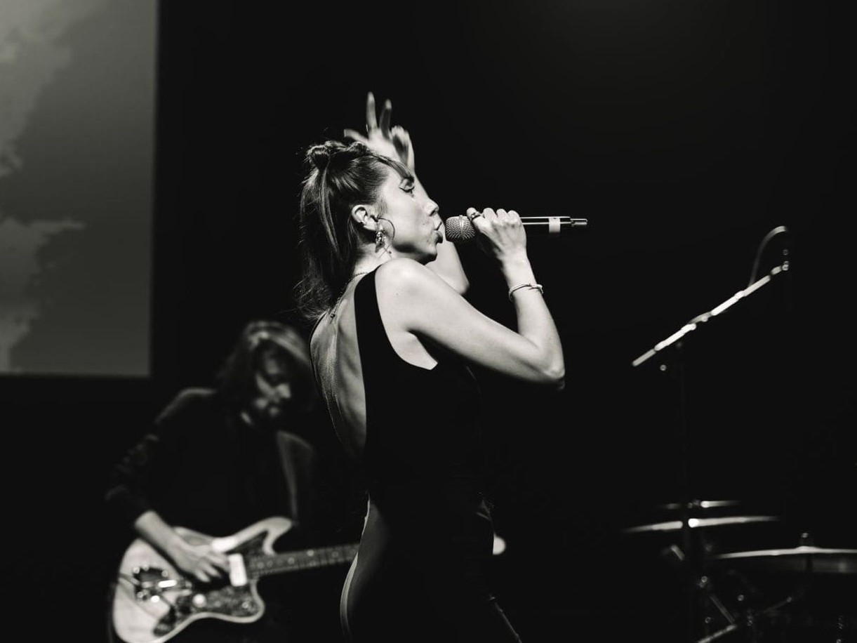 Carolina Jass singt live auf Bühne im Profil – Schwarzweiß-Aufnahme